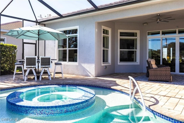 view of swimming pool featuring glass enclosure, an in ground hot tub, ceiling fan, and a patio