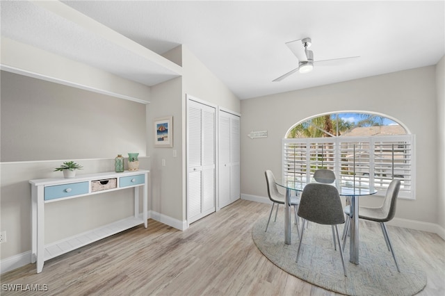 dining area with ceiling fan, light hardwood / wood-style flooring, and vaulted ceiling