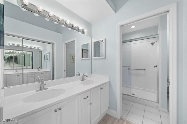 bathroom with tile patterned floors, vanity, and walk in shower