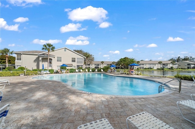 view of pool featuring a patio area and a water view