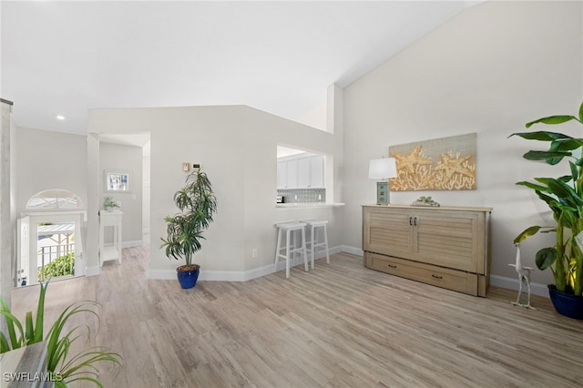 interior space featuring lofted ceiling and light wood-type flooring