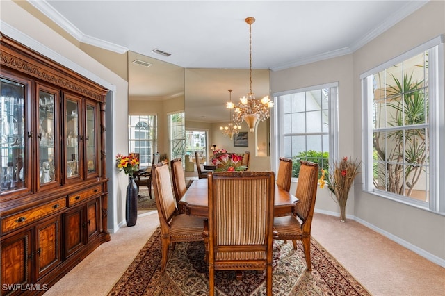 dining room with carpet floors, ornamental molding, and an inviting chandelier