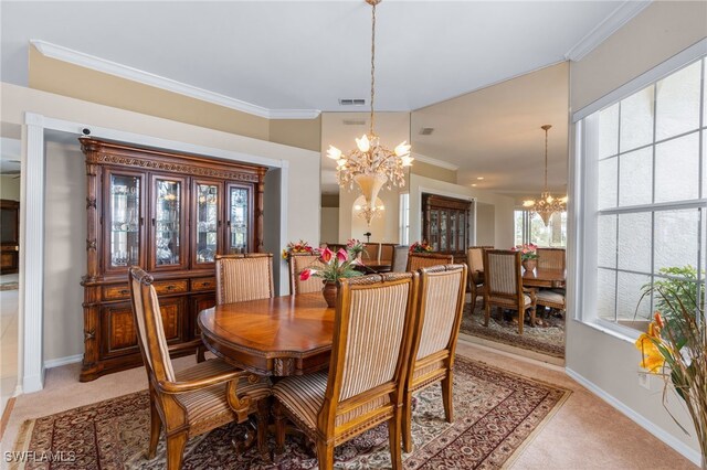 carpeted dining area with a chandelier and ornamental molding