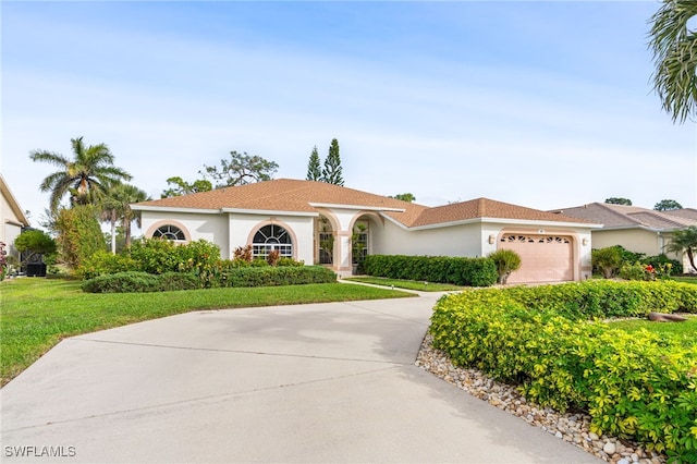 mediterranean / spanish home with a front yard and a garage