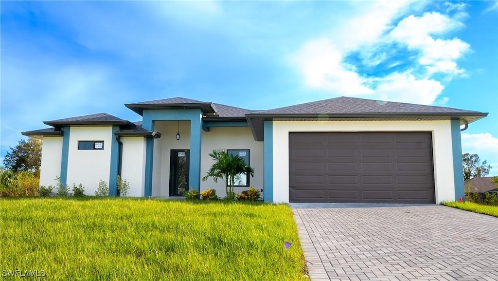 prairie-style home with a garage and a front lawn