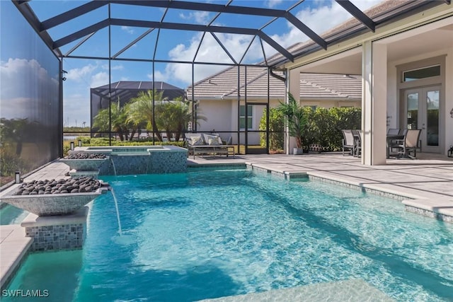 view of pool featuring a lanai, a patio area, a pool with connected hot tub, and french doors