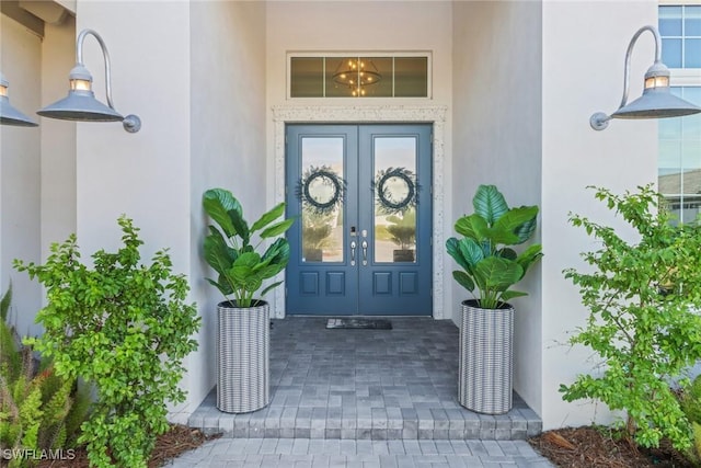 entrance to property featuring stucco siding and french doors