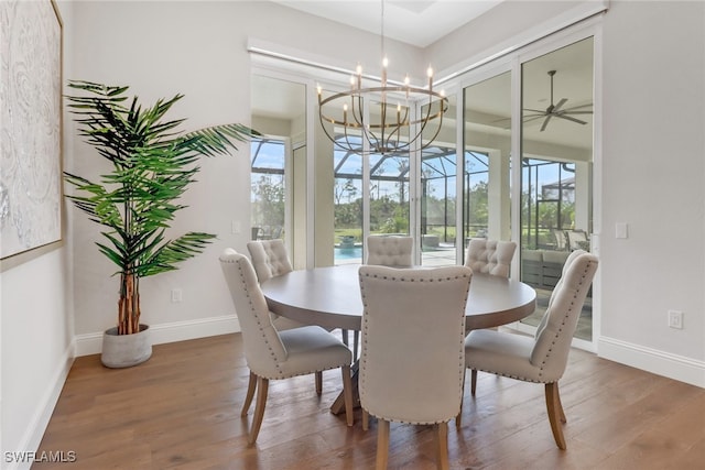 dining area featuring a sunroom, baseboards, and wood finished floors