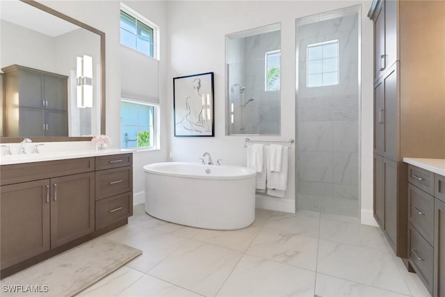 full bath featuring marble finish floor, plenty of natural light, a walk in shower, and vanity