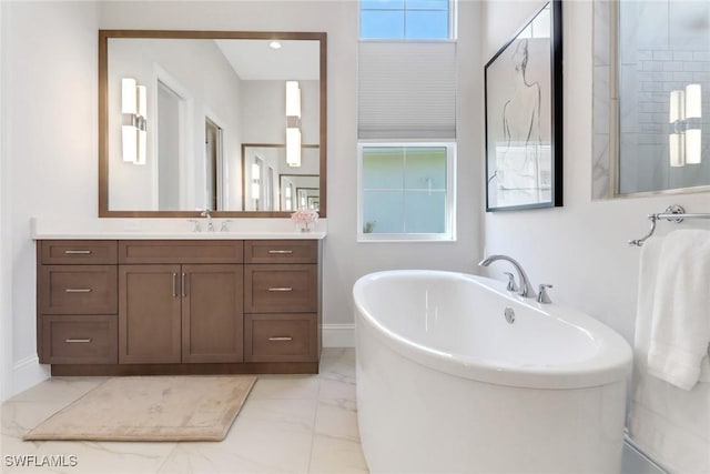 full bathroom featuring marble finish floor, baseboards, a freestanding bath, and vanity