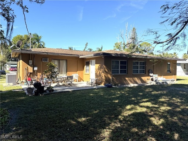 rear view of house with cooling unit, a patio, and a yard