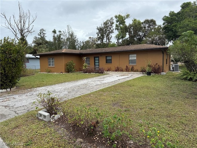 ranch-style home with a front lawn and cooling unit