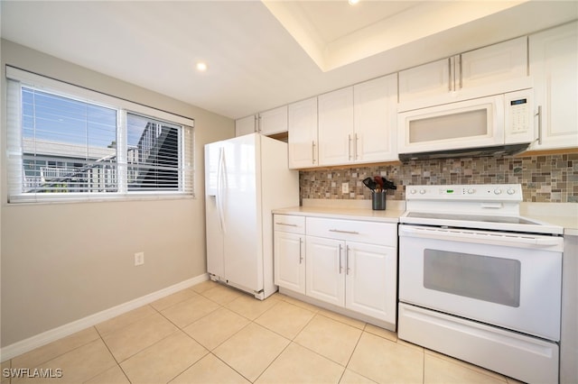 kitchen featuring white cabinetry, a raised ceiling, white appliances, and tasteful backsplash