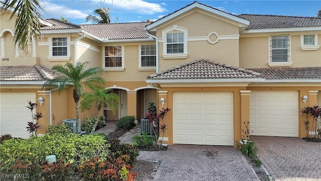 view of front of property with a garage and cooling unit