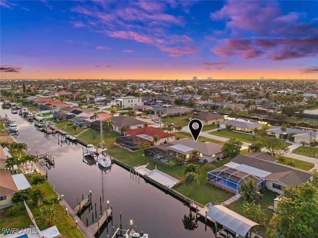 aerial view at dusk featuring a water view