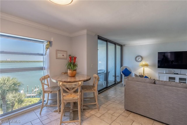 dining area featuring crown molding and a water view