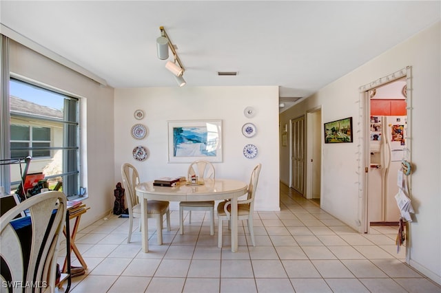 dining room with light tile patterned flooring and track lighting