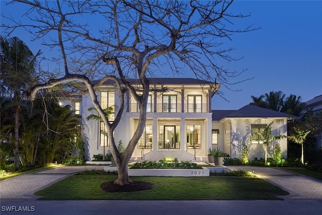 view of front of property with a balcony and a front yard