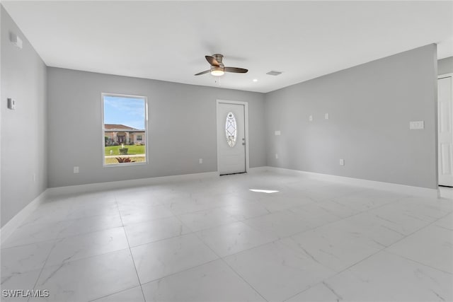 foyer featuring marble finish floor, a ceiling fan, and baseboards