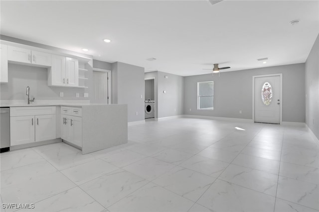 kitchen with washer / dryer, dishwasher, light countertops, white cabinetry, and open shelves