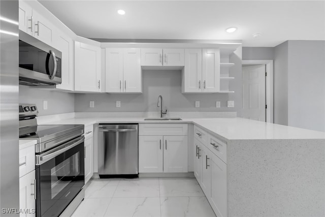 kitchen with stainless steel appliances, light countertops, white cabinetry, open shelves, and a sink