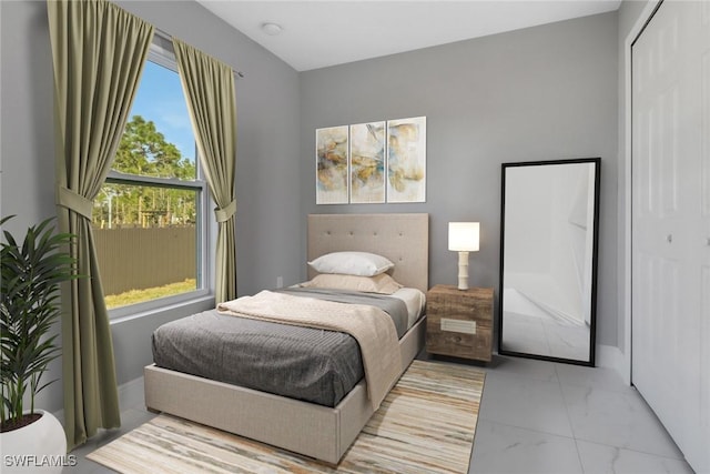 bedroom with marble finish floor, baseboards, and a closet