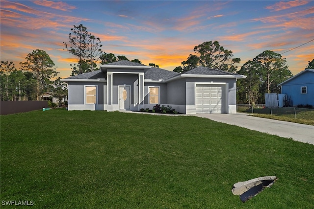 view of front of home featuring a garage, fence, driveway, a lawn, and stucco siding