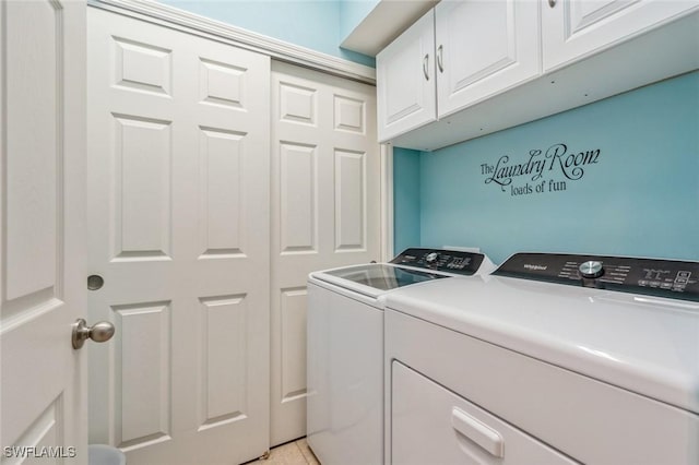 clothes washing area with washer and clothes dryer, light tile patterned flooring, and cabinets