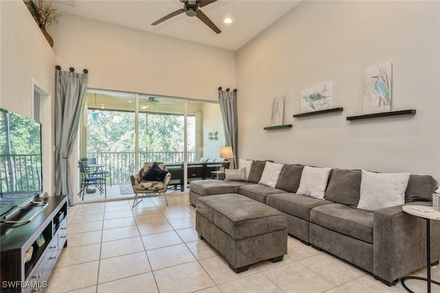 living room featuring ceiling fan, a high ceiling, and light tile patterned flooring