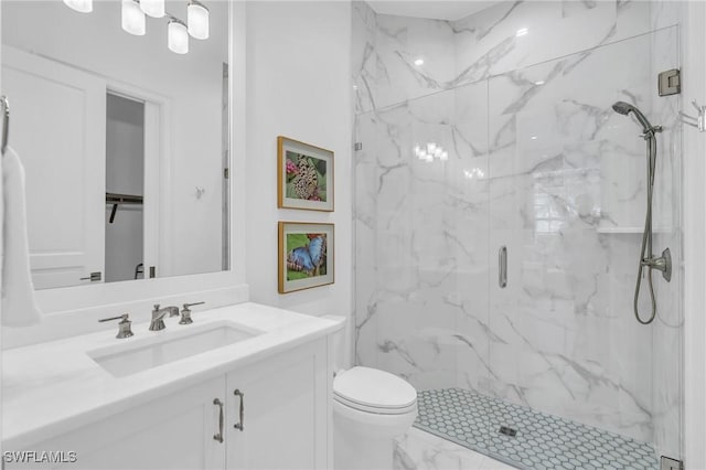 bathroom with vanity, toilet, and a shower with door