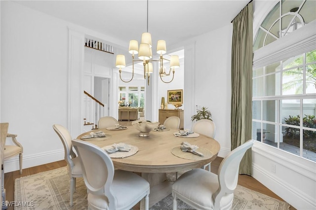 dining room featuring hardwood / wood-style floors, plenty of natural light, and an inviting chandelier