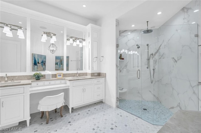 bathroom featuring a shower with door and vanity