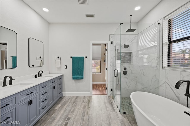 bathroom with wood-type flooring, vanity, and separate shower and tub