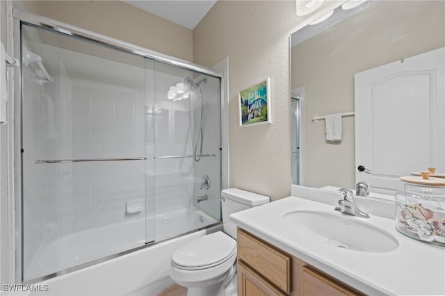 full bathroom featuring combined bath / shower with glass door, toilet, and vanity