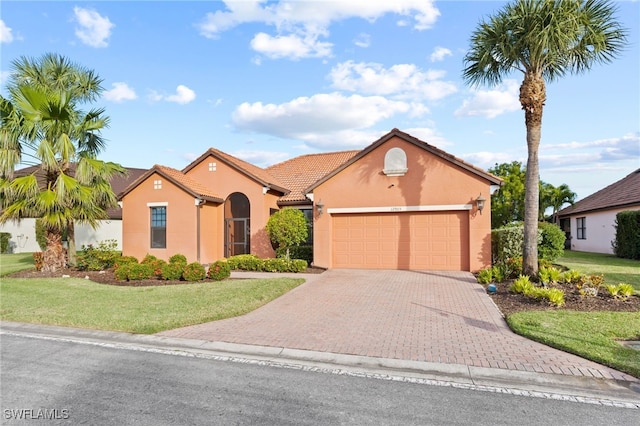 mediterranean / spanish-style house with a garage and a front lawn