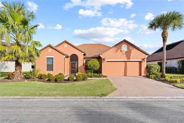 mediterranean / spanish house with a garage and a front lawn