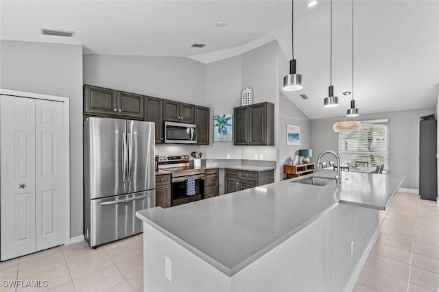 kitchen featuring appliances with stainless steel finishes, decorative light fixtures, light tile patterned floors, and sink