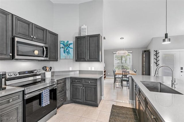 kitchen with sink, stainless steel appliances, light stone counters, decorative light fixtures, and light tile patterned floors