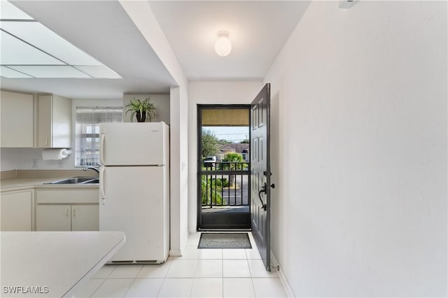 entryway featuring light tile patterned floors and sink