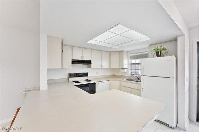 kitchen with kitchen peninsula, white appliances, and sink