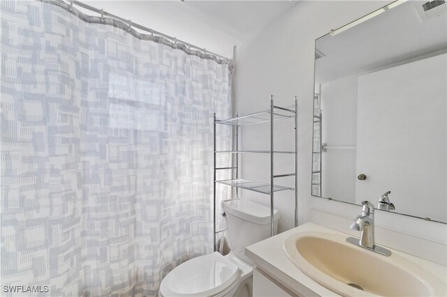 bathroom featuring vanity, a shower with shower curtain, and toilet