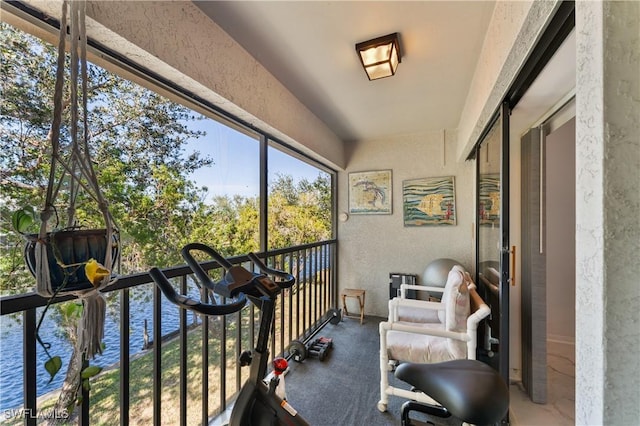 sunroom featuring a water view