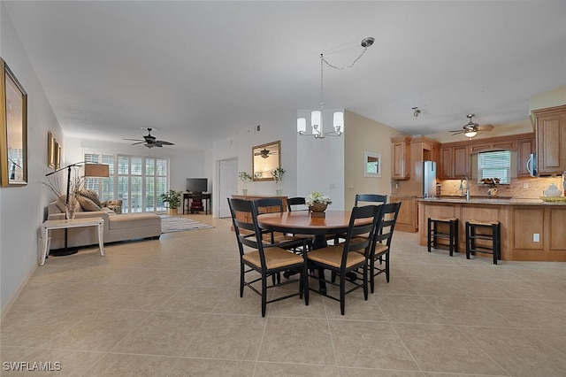 tiled dining room with ceiling fan with notable chandelier and sink