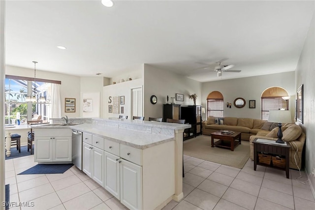 kitchen with stainless steel dishwasher, pendant lighting, light tile patterned floors, white cabinets, and ceiling fan