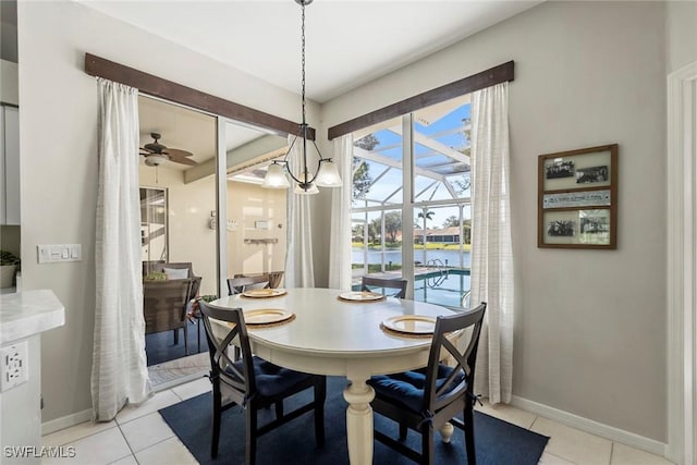 tiled dining area featuring a water view and ceiling fan with notable chandelier