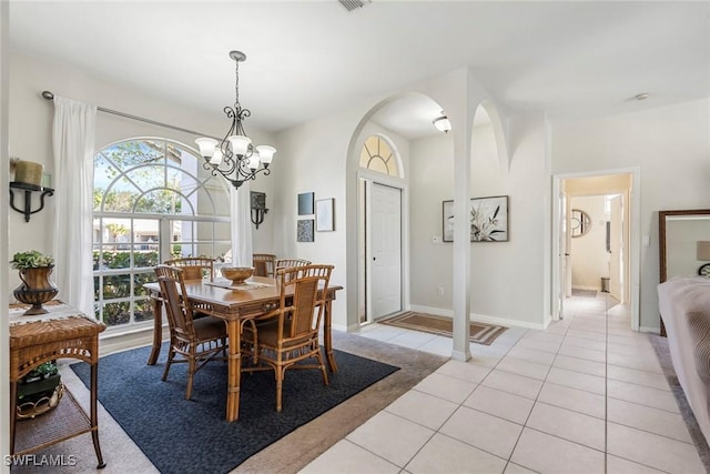 tiled dining room with an inviting chandelier