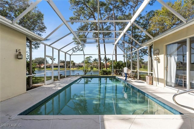 view of pool with a patio area, glass enclosure, and a water view