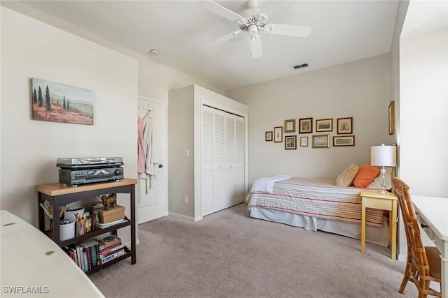 bedroom with ceiling fan, light colored carpet, and a closet