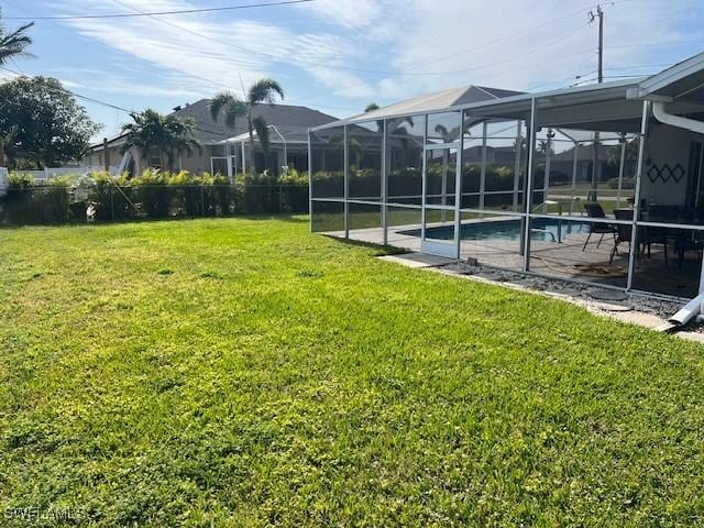 view of yard with glass enclosure and a patio