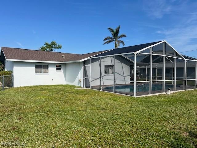 back of house with a lawn and a lanai